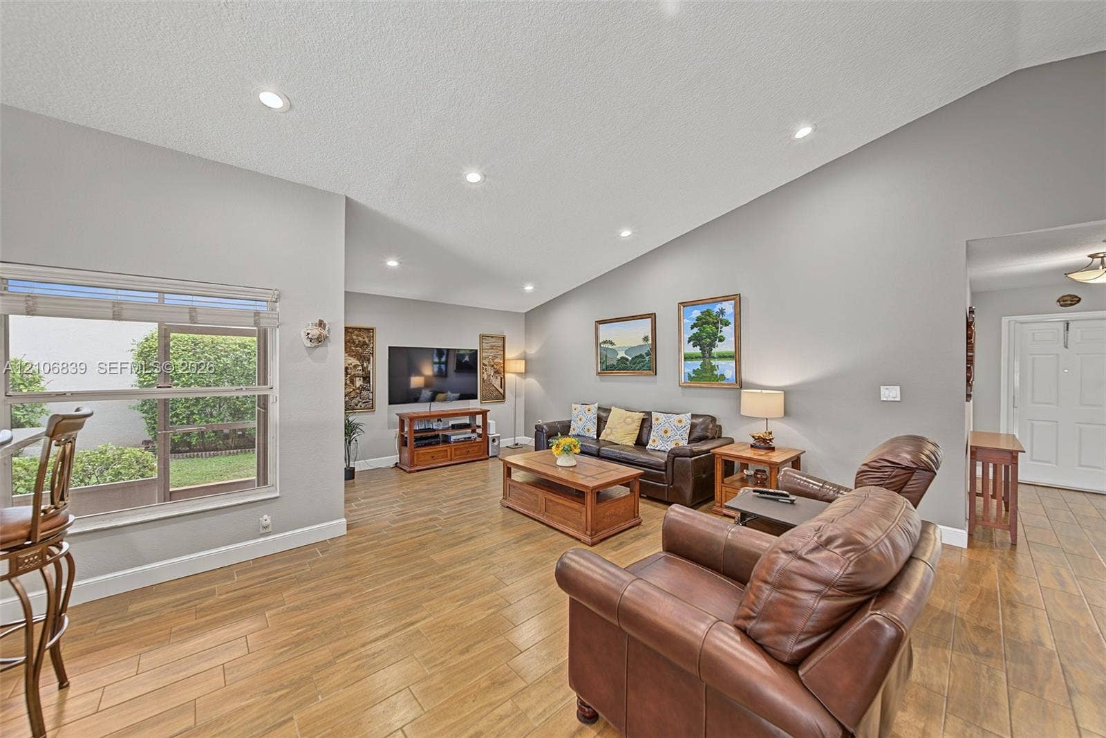 12683 NW 11th Place, Sunrise, FL 33323 Living area featuring vaulted ceilings, recessed lighting, and wood-finish flooring