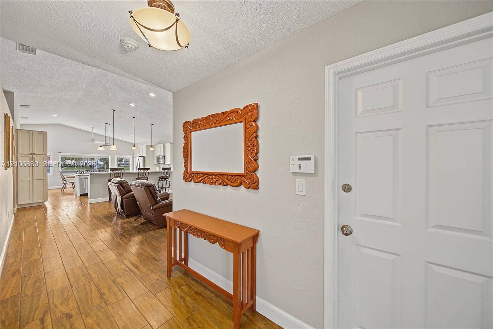 12683 NW 11th Place, Sunrise, FL 33323 Entryway featuring wood-finish flooring, a flush-mount light fixture, and a white paneled door