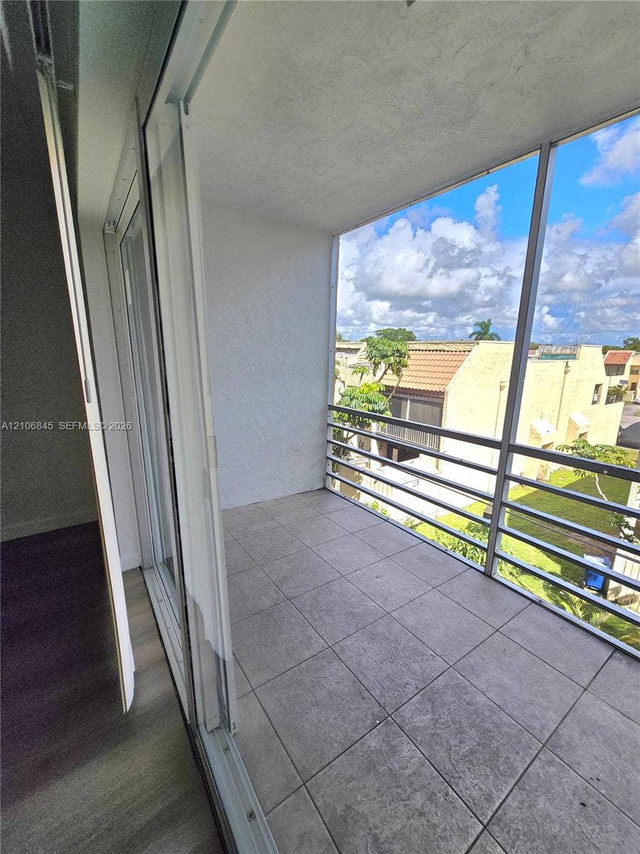 1700 NW 58th Terrace, #3J, Sunrise, Sunrise, FL 33313 Covered balcony featuring tile flooring, aluminum screen enclosure, and sliding glass door access