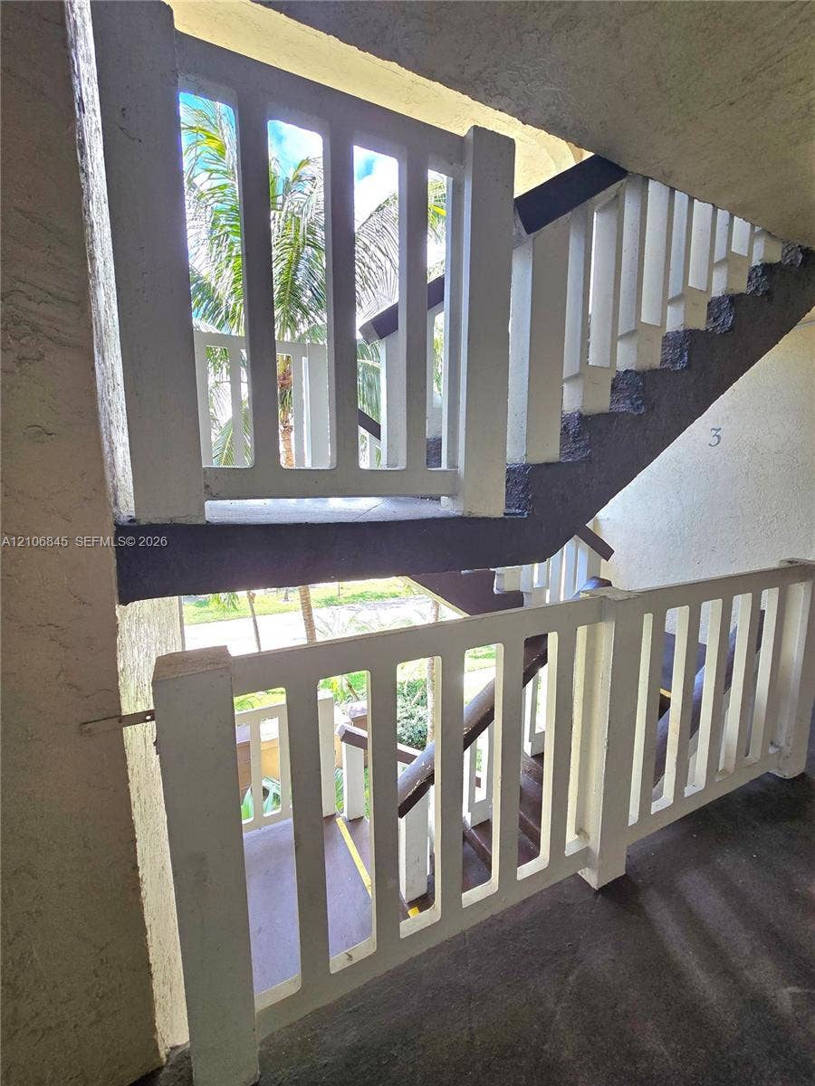 1700 NW 58th Terrace, #3J, Sunrise, Sunrise, FL 33313 Exterior staircase featuring white vertical slat railings, concrete steps, and a dark-toned structural stringer