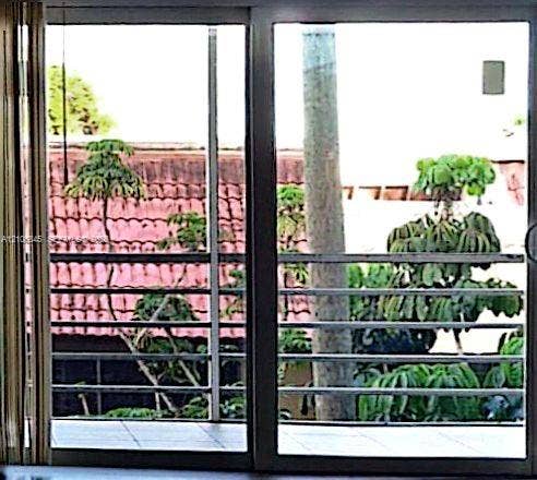 1700 NW 58th Terrace, #3J, Sunrise, Sunrise, FL 33313 Sliding glass door featuring a metal frame, opening to a tiled balcony with horizontal metal railings
