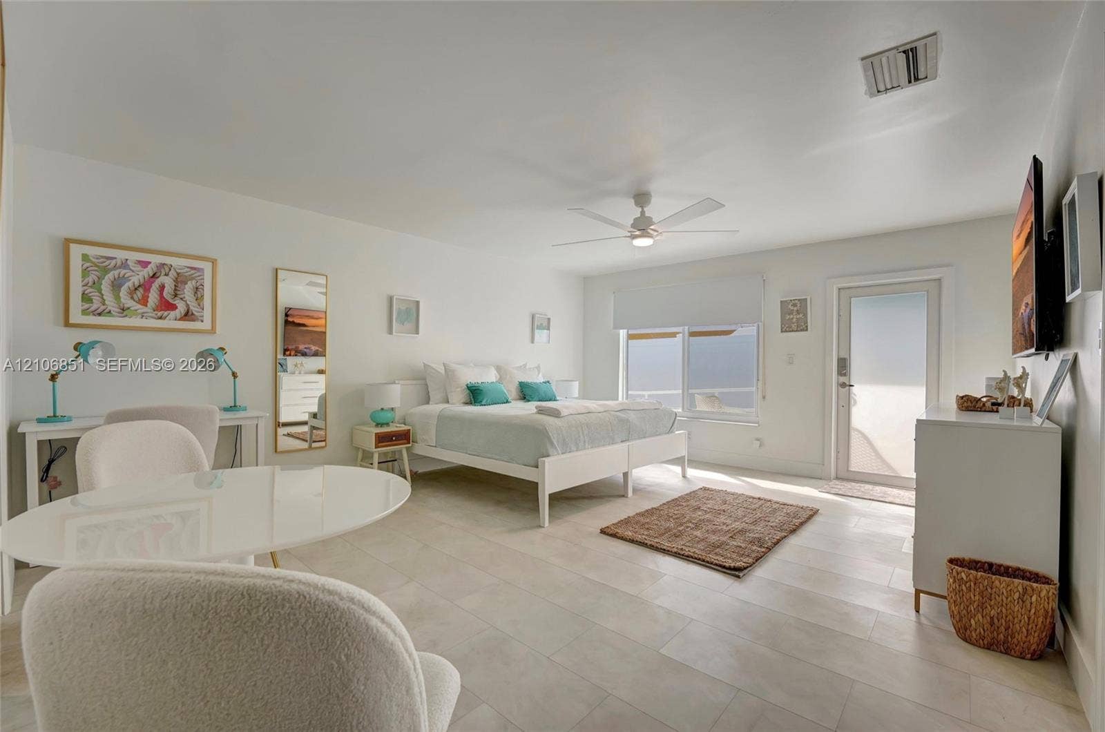 1319 SW 30th Street, #B, Fort Lauderdale, Fort Lauderdale, FL 33315 Spacious room featuring large-format stone-tile flooring, a central ceiling fan, expansive windows, and a glass-paneled exterior door