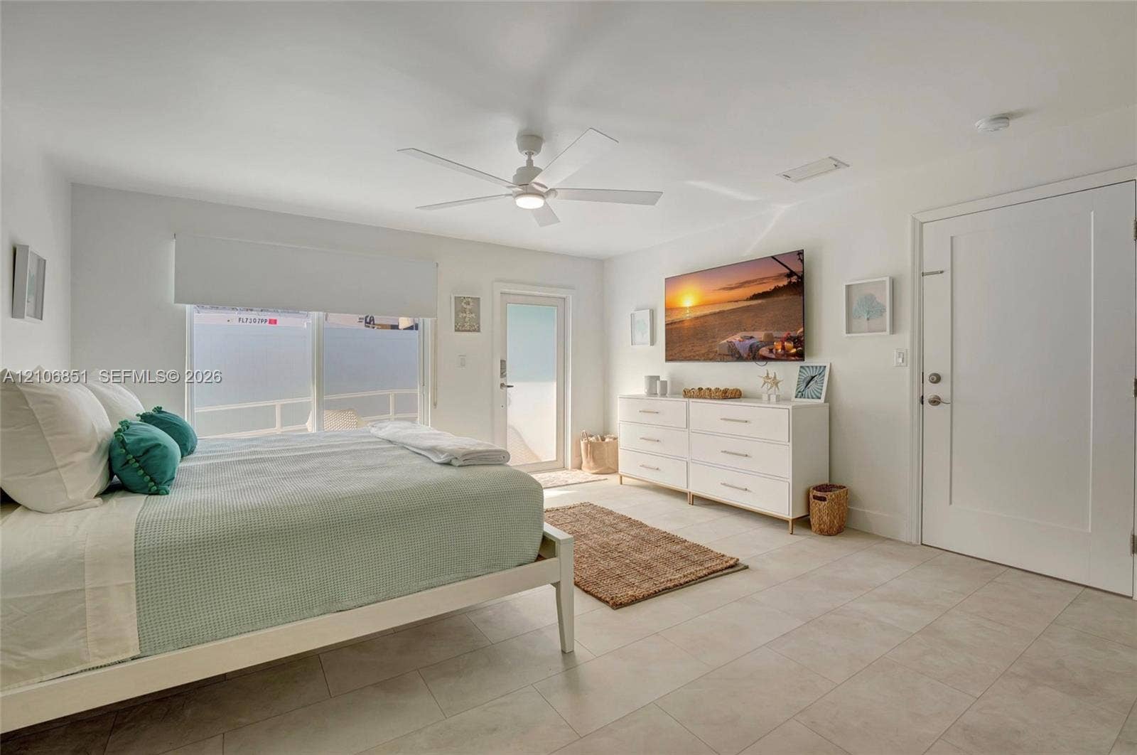 1319 SW 30th Street, #B, Fort Lauderdale, Fort Lauderdale, FL 33315 Bedroom featuring large-format tile flooring, a central ceiling fan with integrated lighting, a sliding glass door, and a paneled entry door