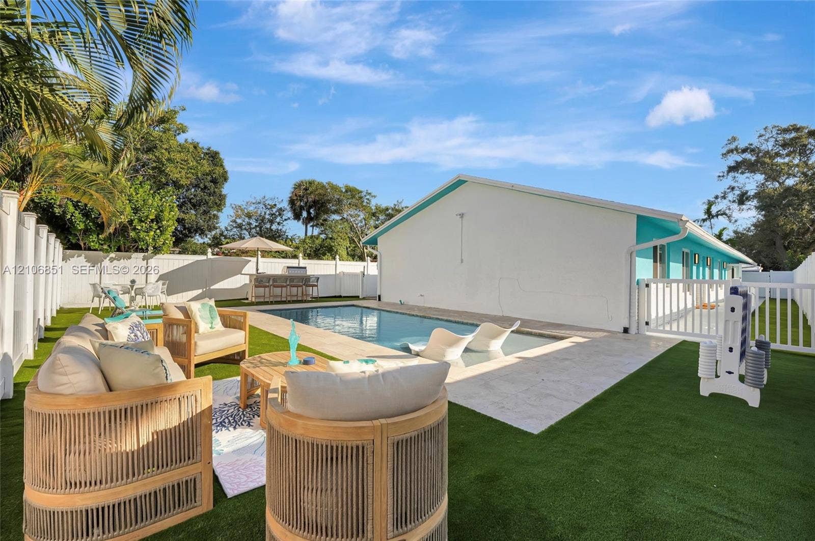 1319 SW 30th Street, #B, Fort Lauderdale, Fort Lauderdale, FL 33315 Outdoor recreation area featuring a rectangular swimming pool, stone-paver pool deck, synthetic lawn, and perimeter vinyl fencing