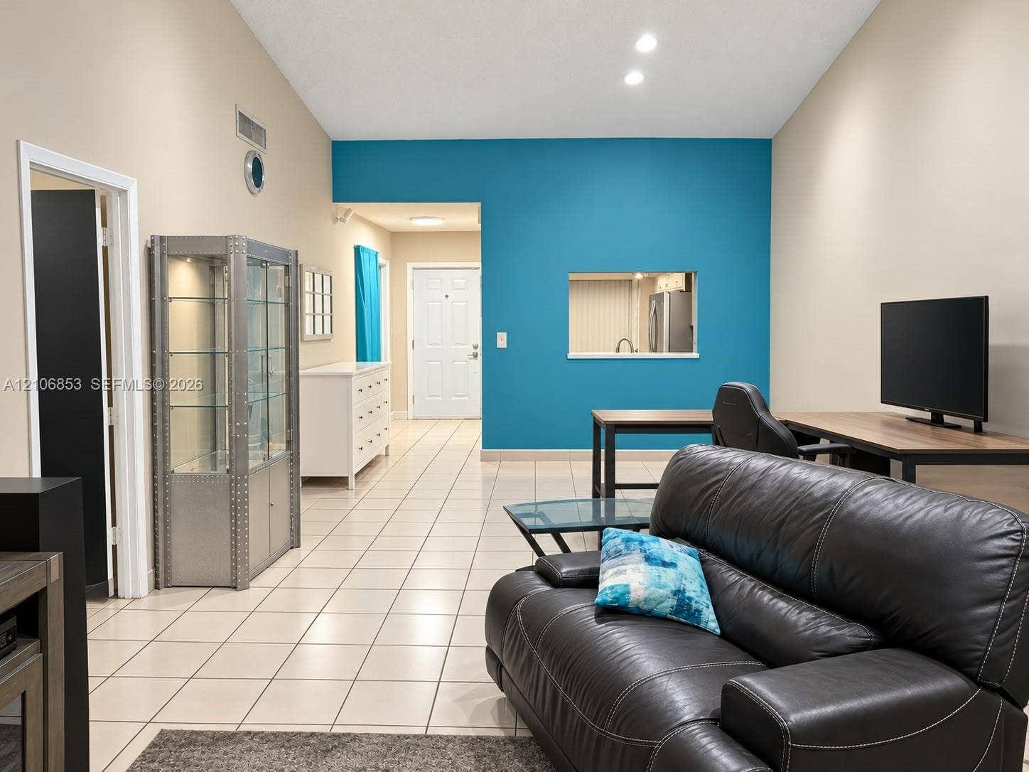 6331 Pinehurst Circle W, #C35, Tamarac, FL 33321 Living area featuring vaulted ceilings, ceramic tile flooring, and a recessed wall pass-through