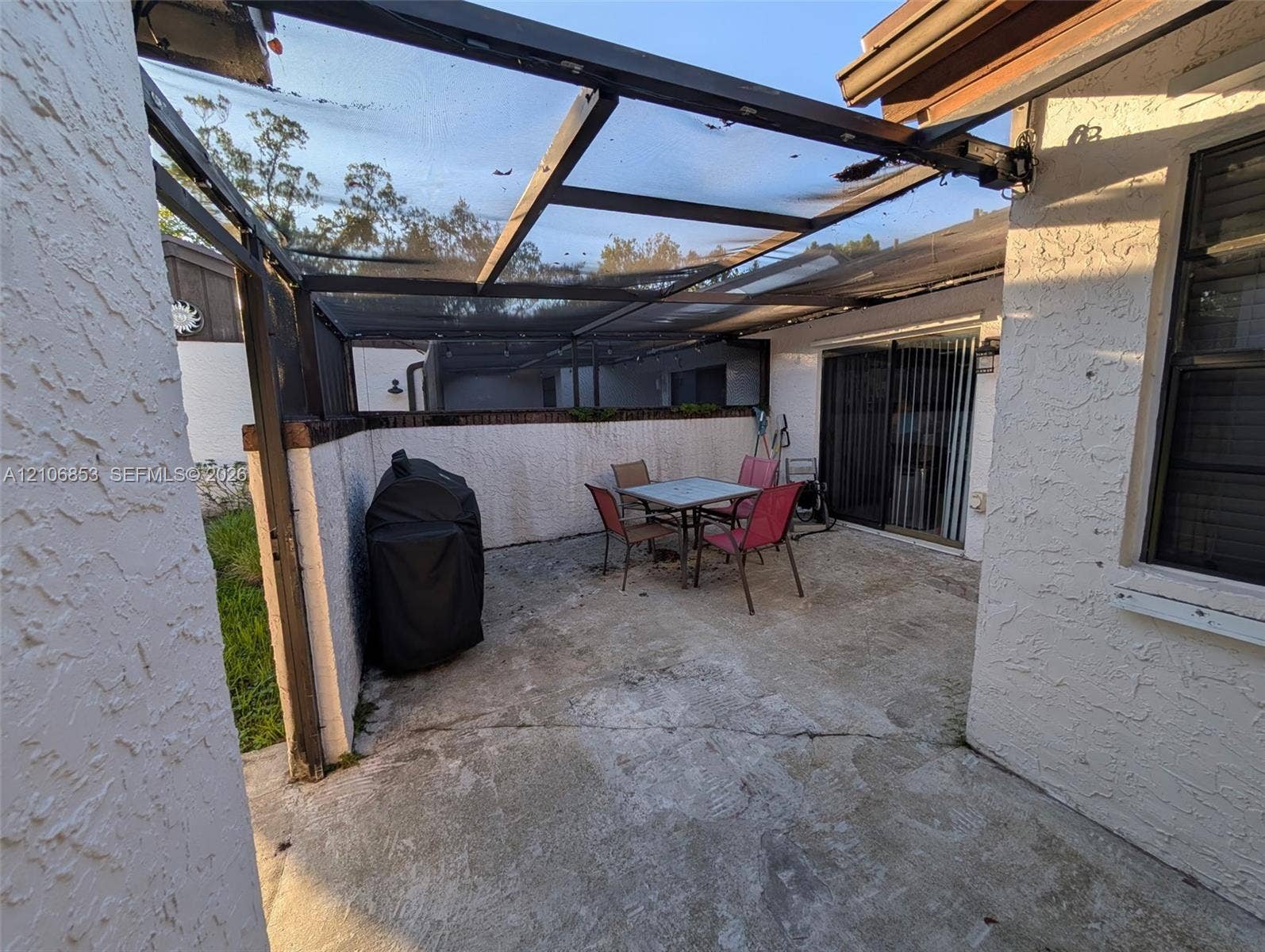 6331 Pinehurst Circle W, #C35, Tamarac, FL 33321 Enclosed outdoor patio featuring a concrete surface, stucco walls, and a metal-framed screened overhead structure