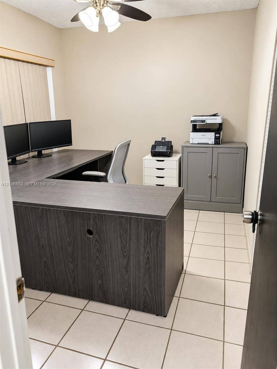 6331 Pinehurst Circle W, #C35, Tamarac, FL 33321 Neutral-toned interior room featuring tile flooring, vertical window blinds, and a ceiling-mounted light fixture with a fan