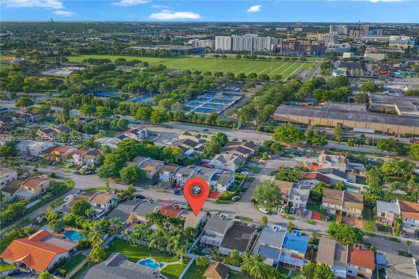10960 SW 25th Street, Miami, FL 33165 Aerial perspective of a suburban neighborhood featuring a multi-story residential structure, tile roofing, and private outdoor recreational space with a swimming pool