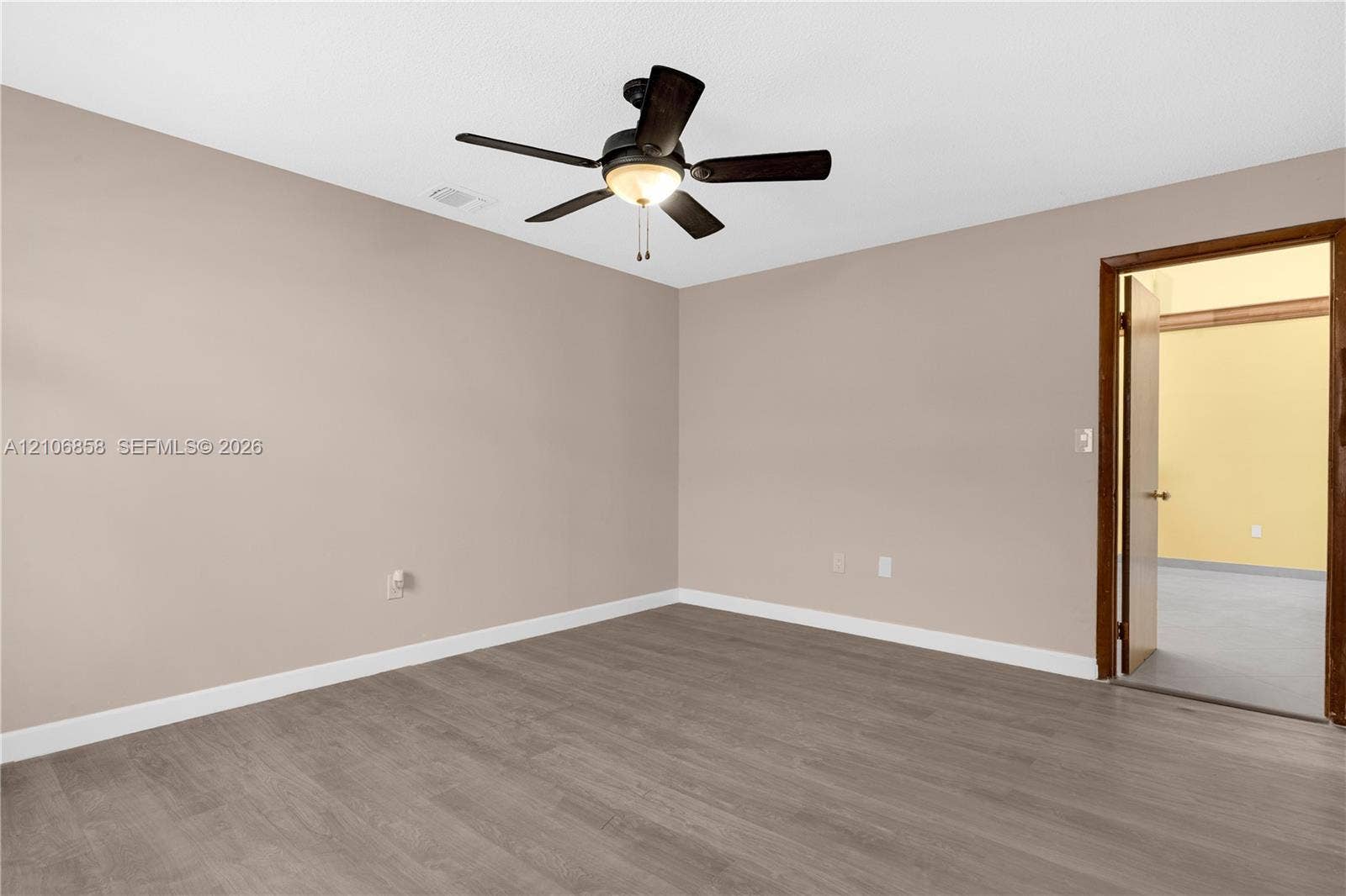 10960 SW 25th Street, Miami, FL 33165 Interior room featuring wood-finish flooring, neutral wall paint, and a central ceiling fan with integrated lighting