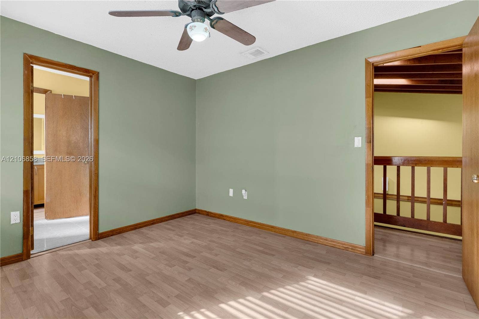 10960 SW 25th Street, Miami, FL 33165 Interior room featuring wood-finish flooring, a ceiling fan with integrated lighting, and wooden door trim