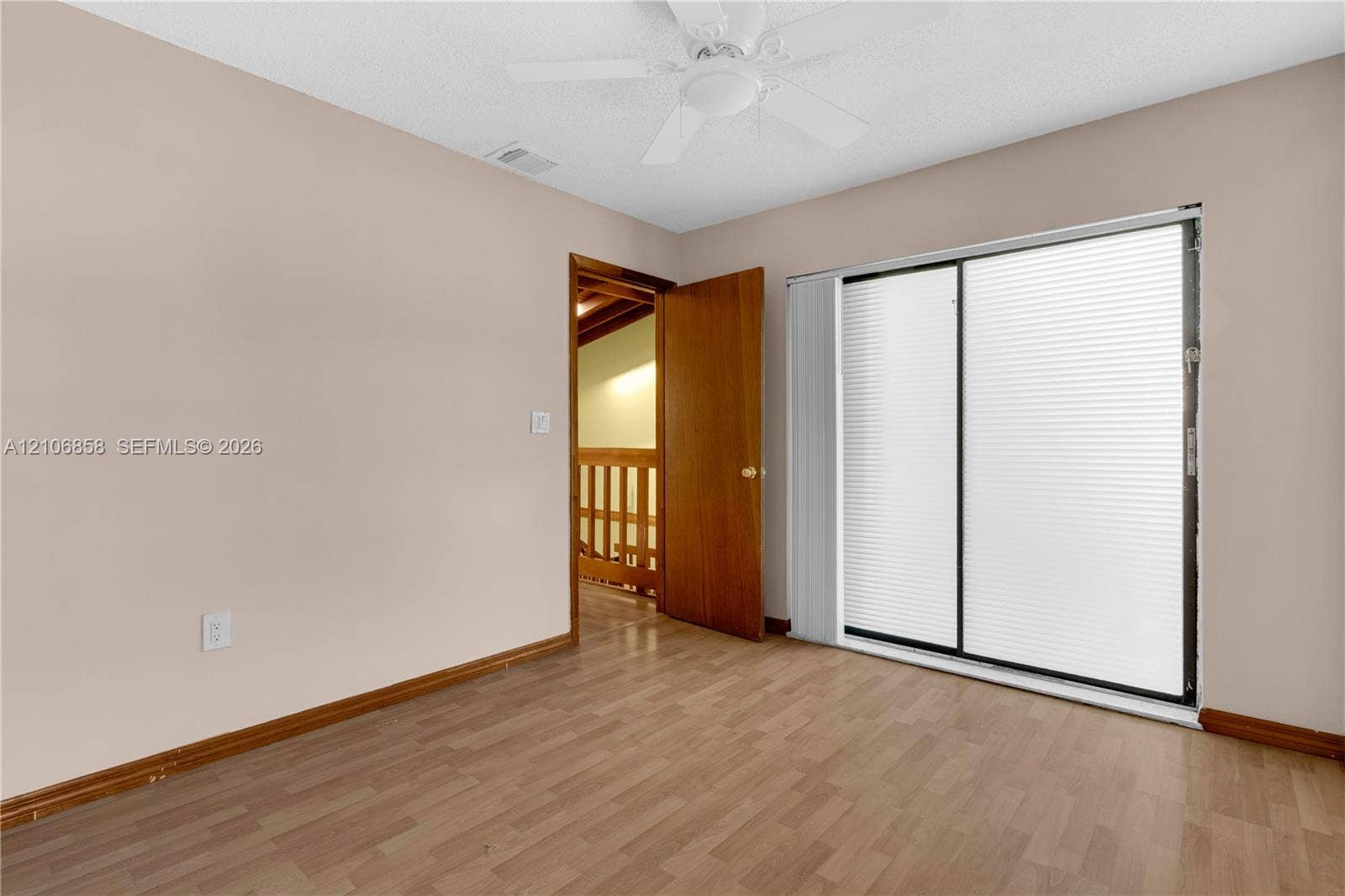 10960 SW 25th Street, Miami, FL 33165 Interior room featuring wood-finish flooring, a ceiling fan, and sliding glass doors with integrated blinds