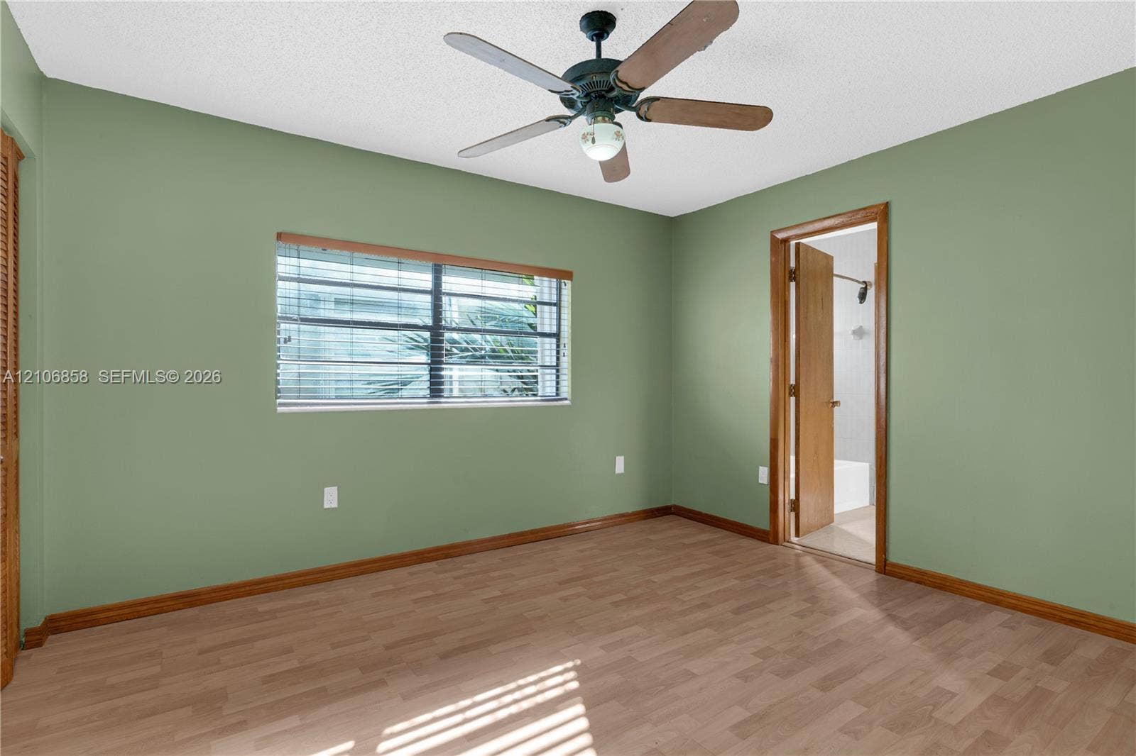 10960 SW 25th Street, Miami, FL 33165 Interior space featuring wood-finish flooring, a multi-blade ceiling fan, and window with integrated blinds