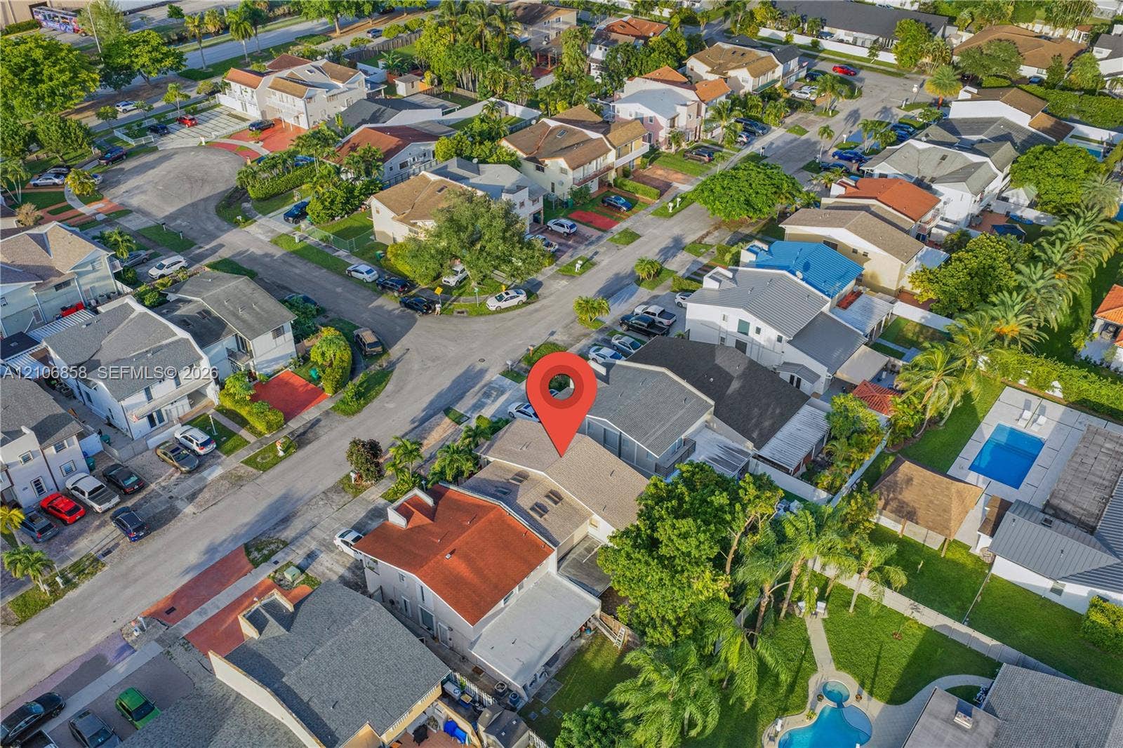 10960 SW 25th Street, Miami, FL 33165 Aerial perspective of a multi-level residence featuring a pitched roof, integrated skylights, and residential street frontage within a platted subdivision