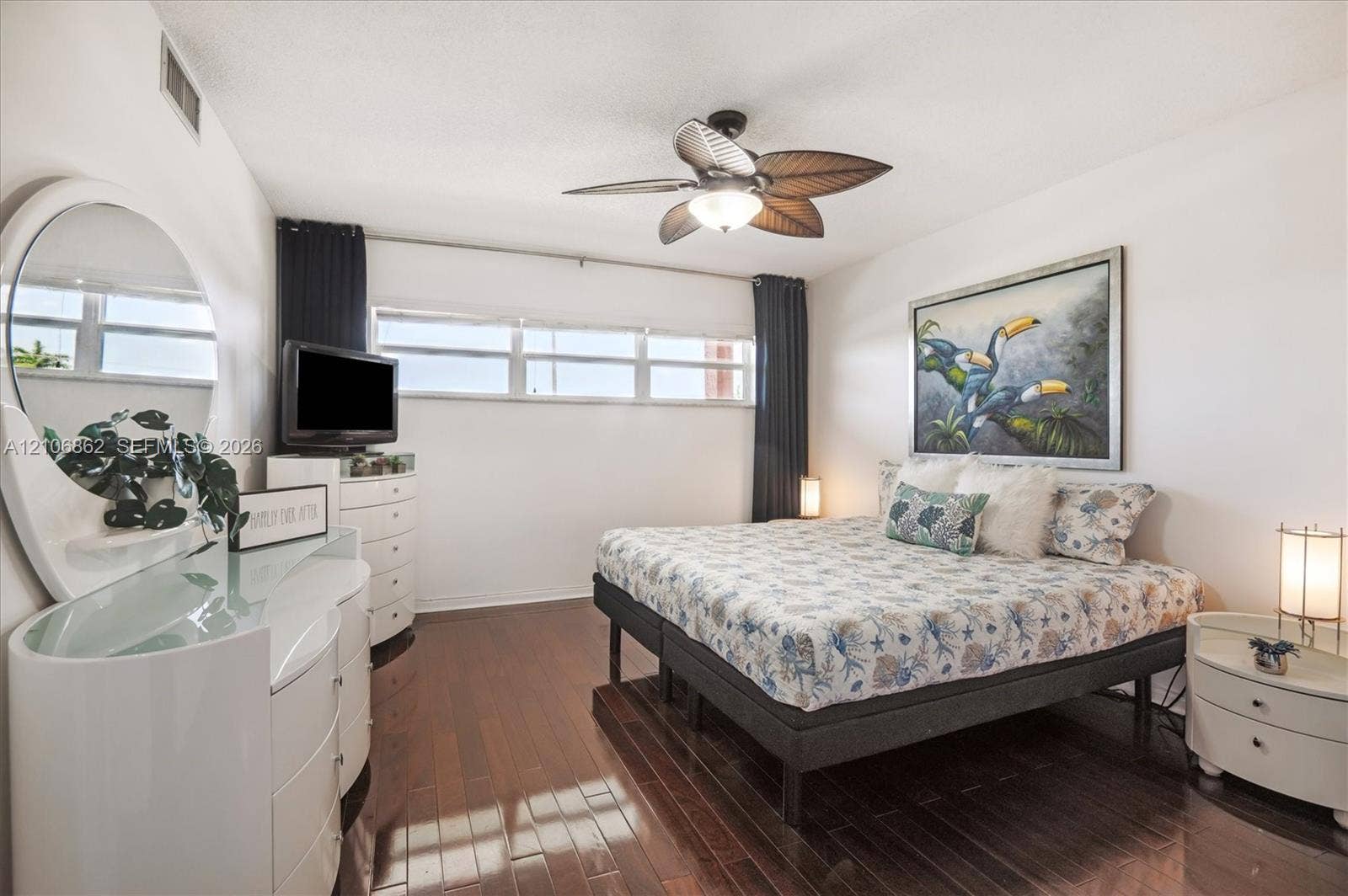 Wood-finish flooring, horizontal windows, and a ceiling fan with leaf-shaped blades