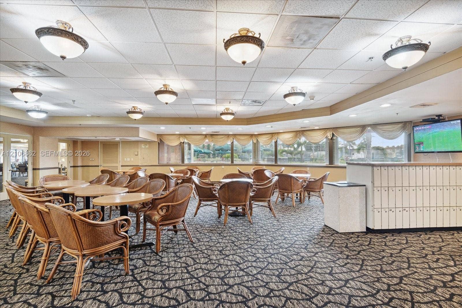 Common area featuring expansive floor-to-ceiling windows, drop ceiling with recessed lighting fixtures, and custom-fit wall mailboxes