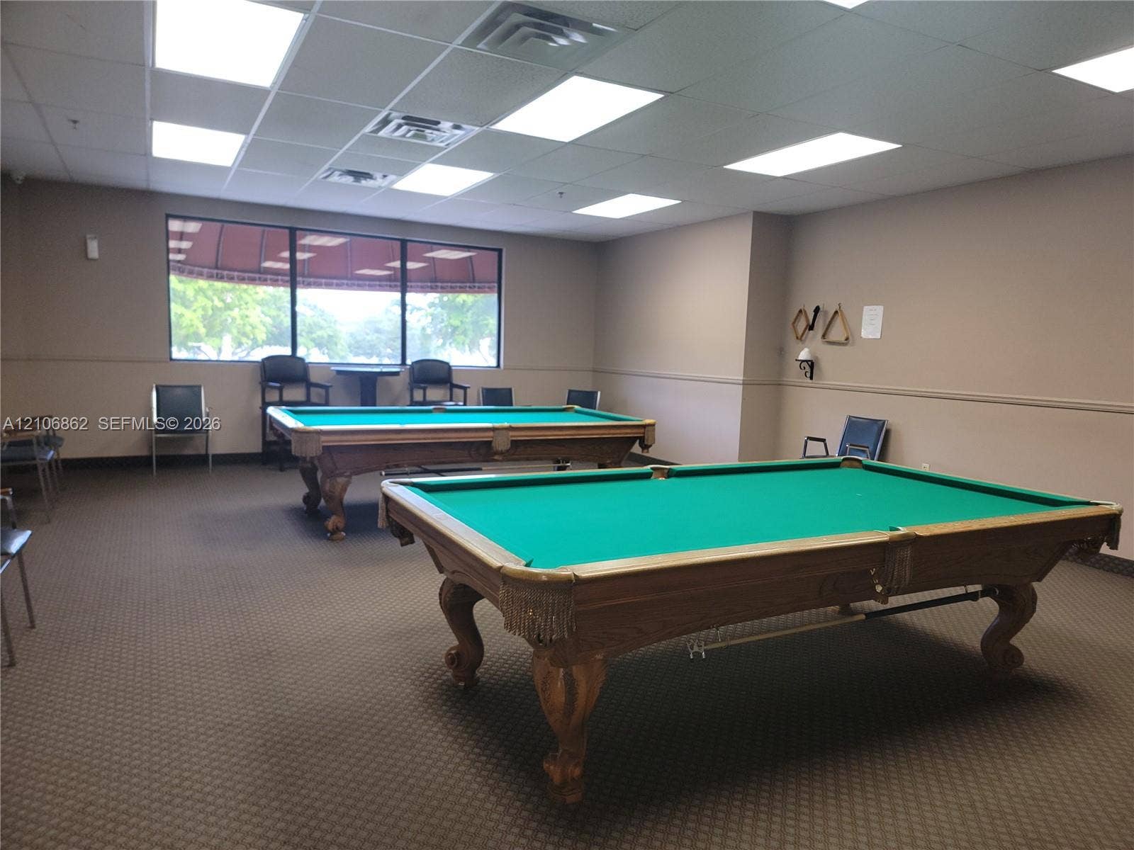 Spacious room featuring a drop ceiling with recessed lighting and carpeted flooring