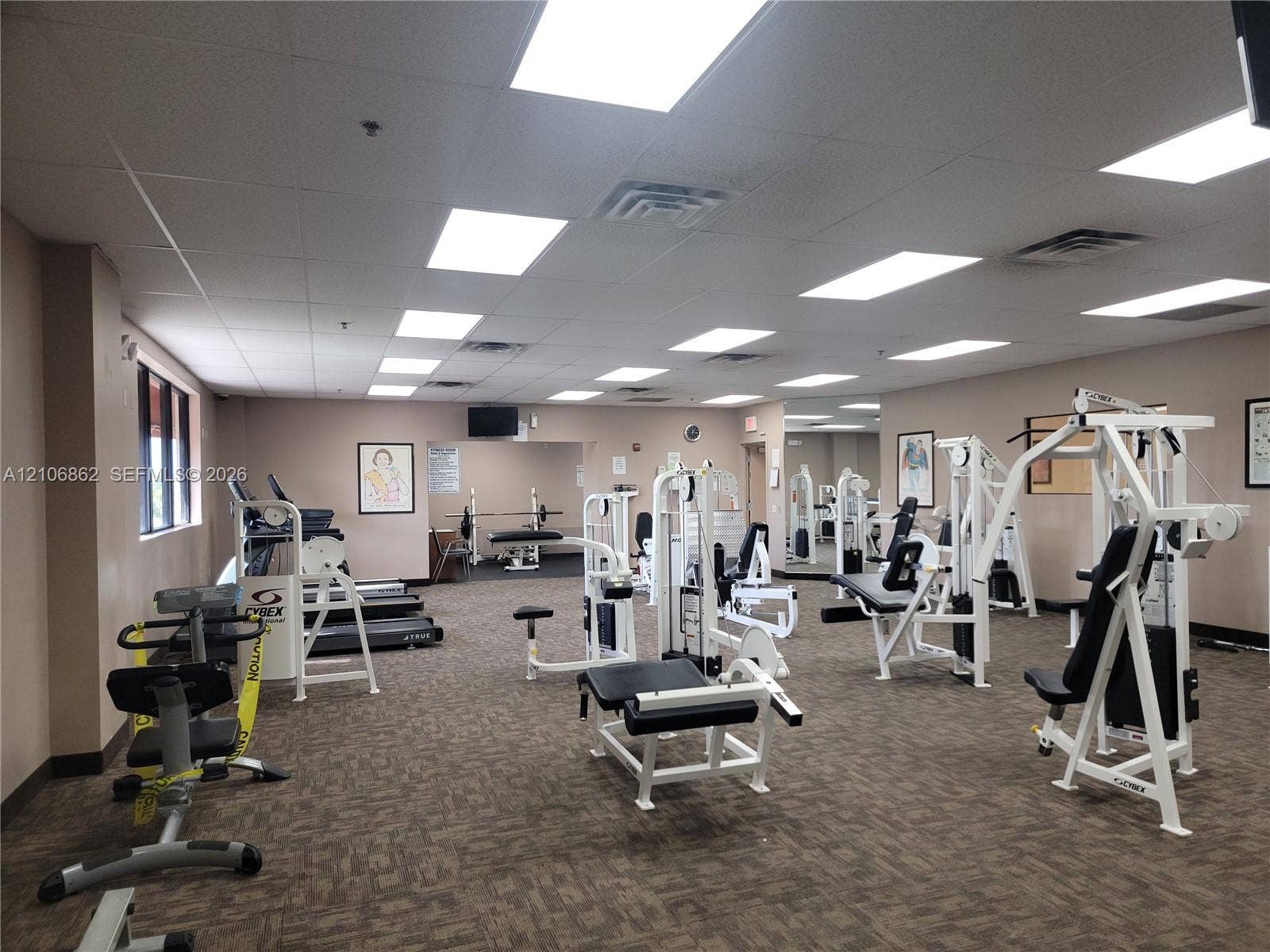 Fitness room featuring recessed lighting, a drop ceiling, wall-to-wall carpeting, and a full-length wall mirror