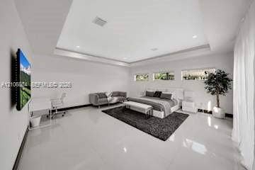 885 SW 144th Avenue, Miami, FL 33184 Spacious room featuring a deep tray ceiling, high-gloss tile flooring, and three horizontal clerestory windows