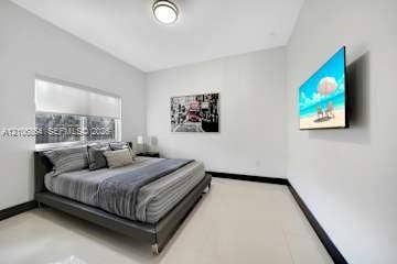 885 SW 144th Avenue, Miami, FL 33184 Neutral interior featuring high-gloss tile flooring, smooth wall finish, recessed ceiling lighting, and a window with a retractable roller shade