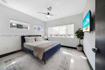 885 SW 144th Avenue, Miami, FL 33184 Neutral-toned room featuring high-gloss flooring, recessed lighting, a modern ceiling fan, and large windows providing natural light