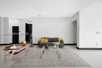 885 SW 144th Avenue, Miami, FL 33184 Open-concept living space featuring high ceilings with recessed lighting, crisp white wall finishes, polished hard-surface flooring, and high-contrast dark door frames