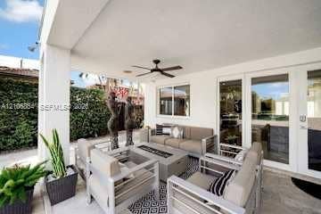 885 SW 144th Avenue, Miami, FL 33184 Covered patio featuring a recessed ceiling, mounted ceiling fan, stone-style flooring, and glass-paneled entry doors