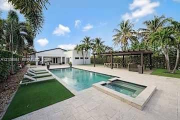 885 SW 144th Avenue, Miami, FL 33184 Outdoor living space featuring an in-ground swimming pool, raised spa, stone-finish patio, and a covered pergola