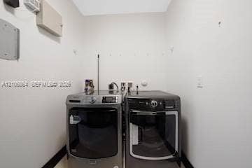 885 SW 144th Avenue, Miami, FL 33184 Laundry area featuring dark metallic-finish washer and dryer units with digital control panels and clear-view glass doors