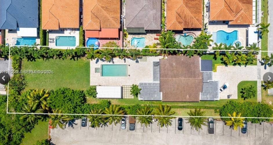 885 SW 144th Avenue, Miami, FL 33184 Aerial perspective of a sprawling parcel featuring a rectangular swimming pool, extensive paved patio, manicured lawn, and perimeter landscaping