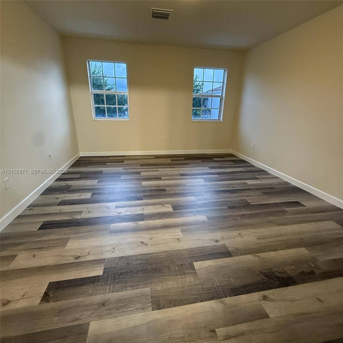 Interior space featuring wood-finish flooring and two grid-pattern windows