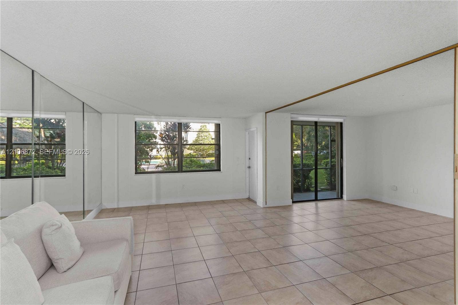 Interior space featuring tile flooring, mirrored wall panels, and multiple windowed exposures