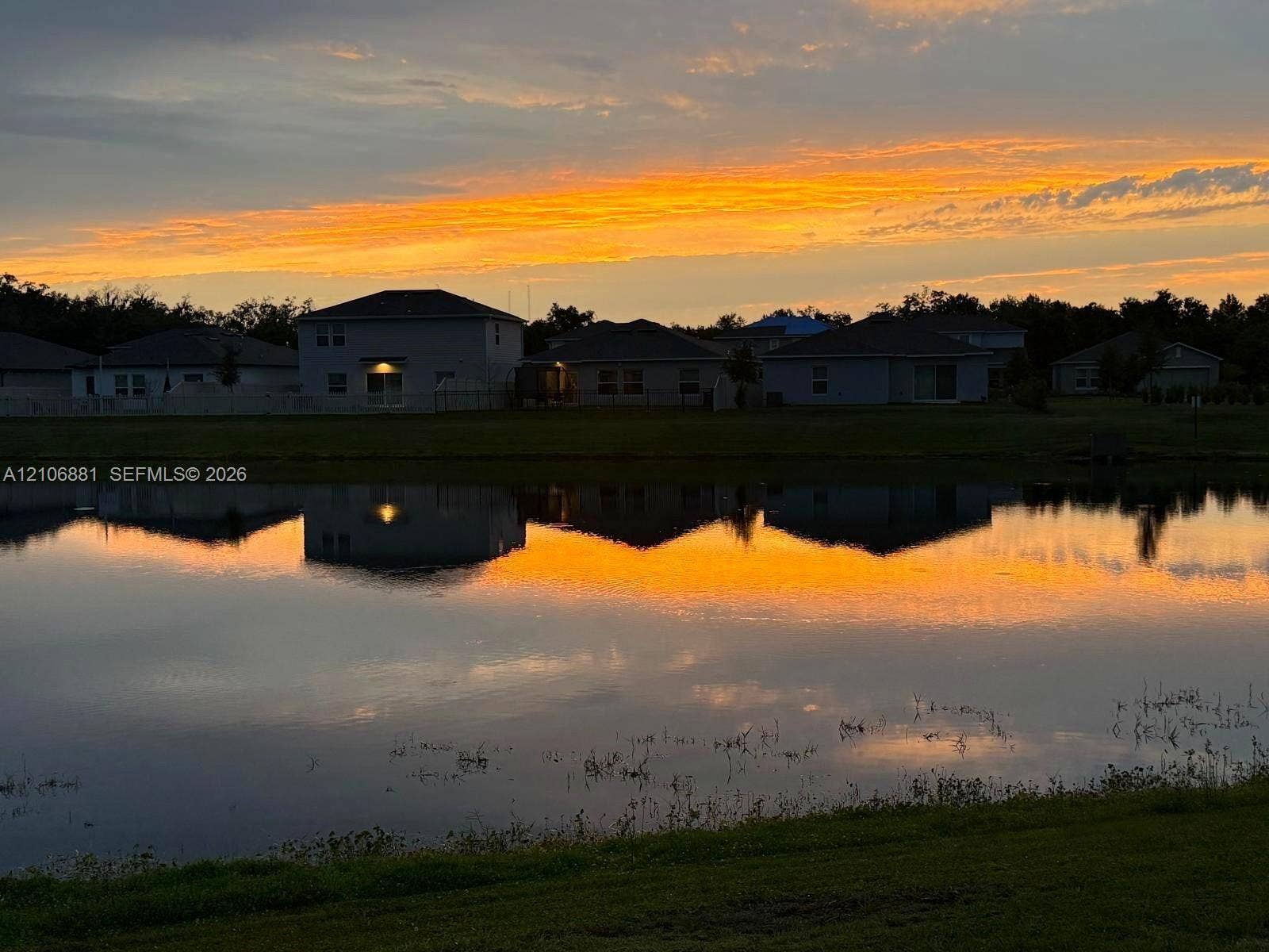 Waterfront property featuring a body of water and a sunset backdrop