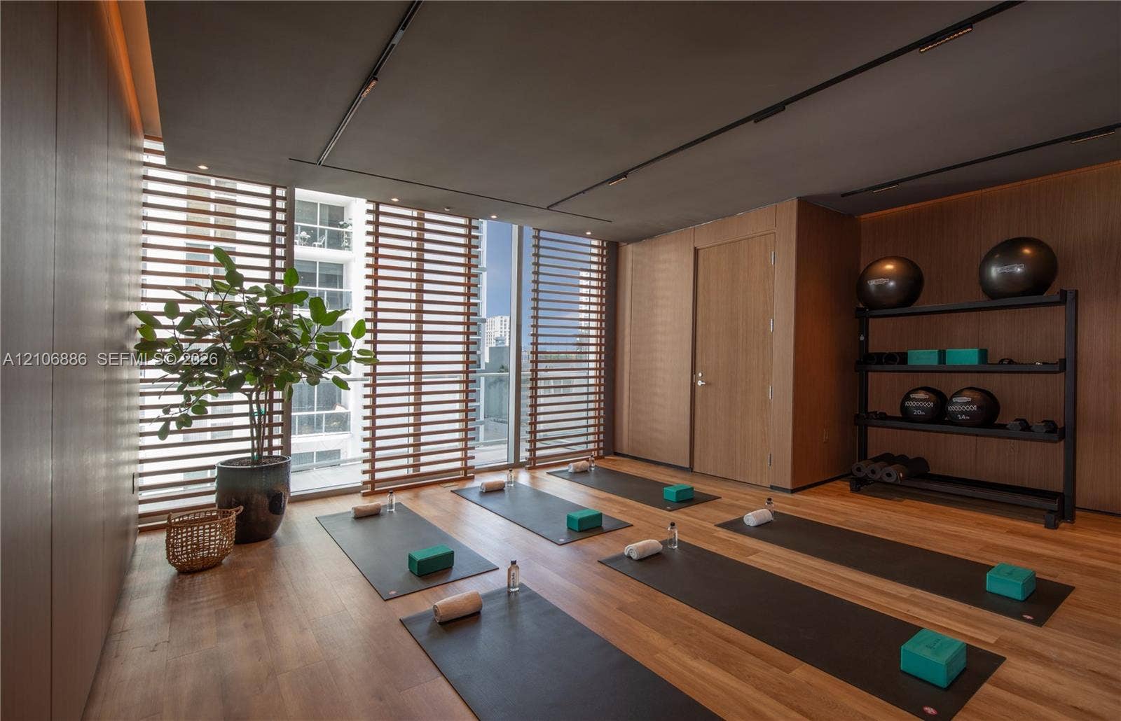 1400 Biscayne Boulevard, #2603, Miami, FL 33132 Wood-finish flooring, floor-to-ceiling windows with integrated horizontal slat screening, and wall-to-wall wood-paneling featuring recessed ceiling track lighting