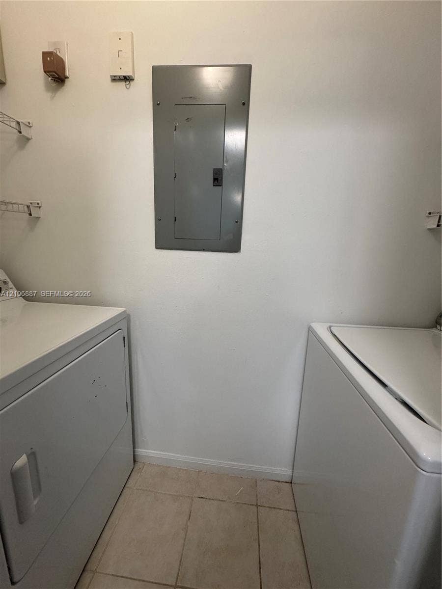 7950 N Nob Hill Road, #202, Tamarac, Tamarac, FL 33321 Dedicated utility space featuring tile flooring and wall-mounted wire shelving