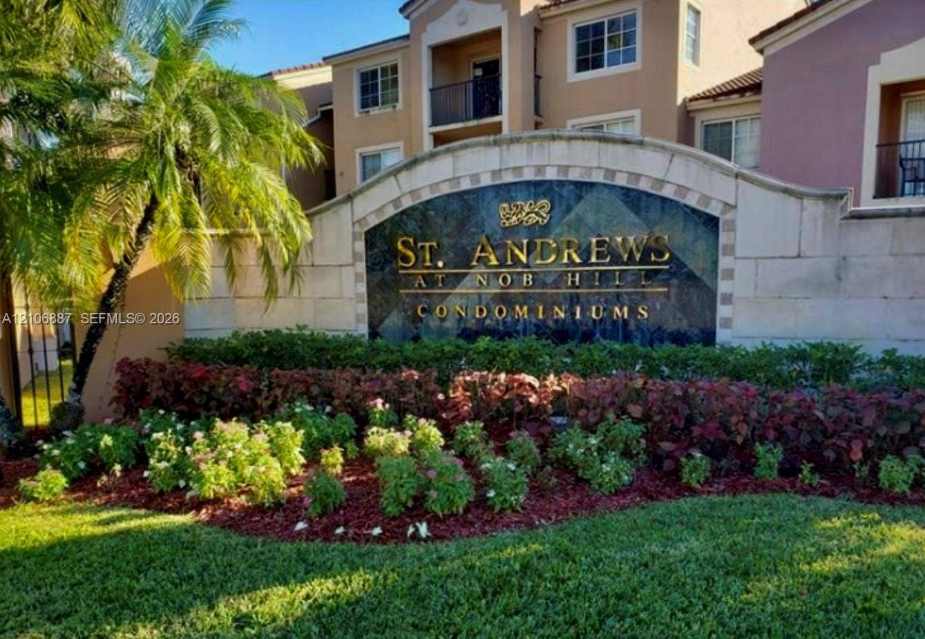 7950 N Nob Hill Road, #202, Tamarac, Tamarac, FL 33321 Monument sign featuring stone-finish masonry, ornamental metal lettering, integrated landscaping, and palm accents