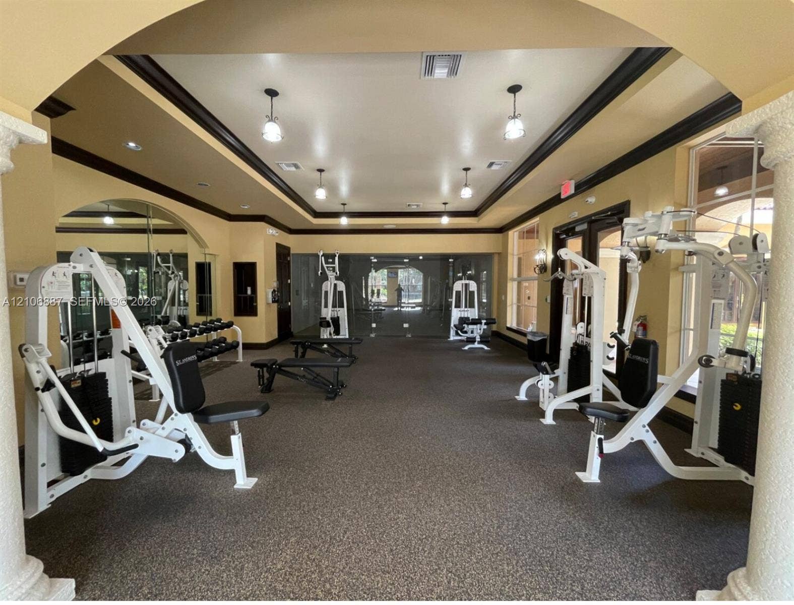 7950 N Nob Hill Road, #202, Tamarac, Tamarac, FL 33321 Fitness center featuring decorative columns, crown molding, recessed lighting, and wall-to-wall carpeting