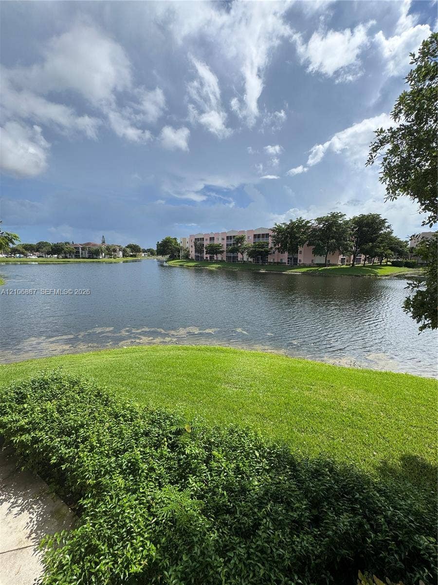 7950 N Nob Hill Road, #202, Tamarac, Tamarac, FL 33321 Waterfront scenery featuring a expansive lake, manicured lawn, and mature greenery