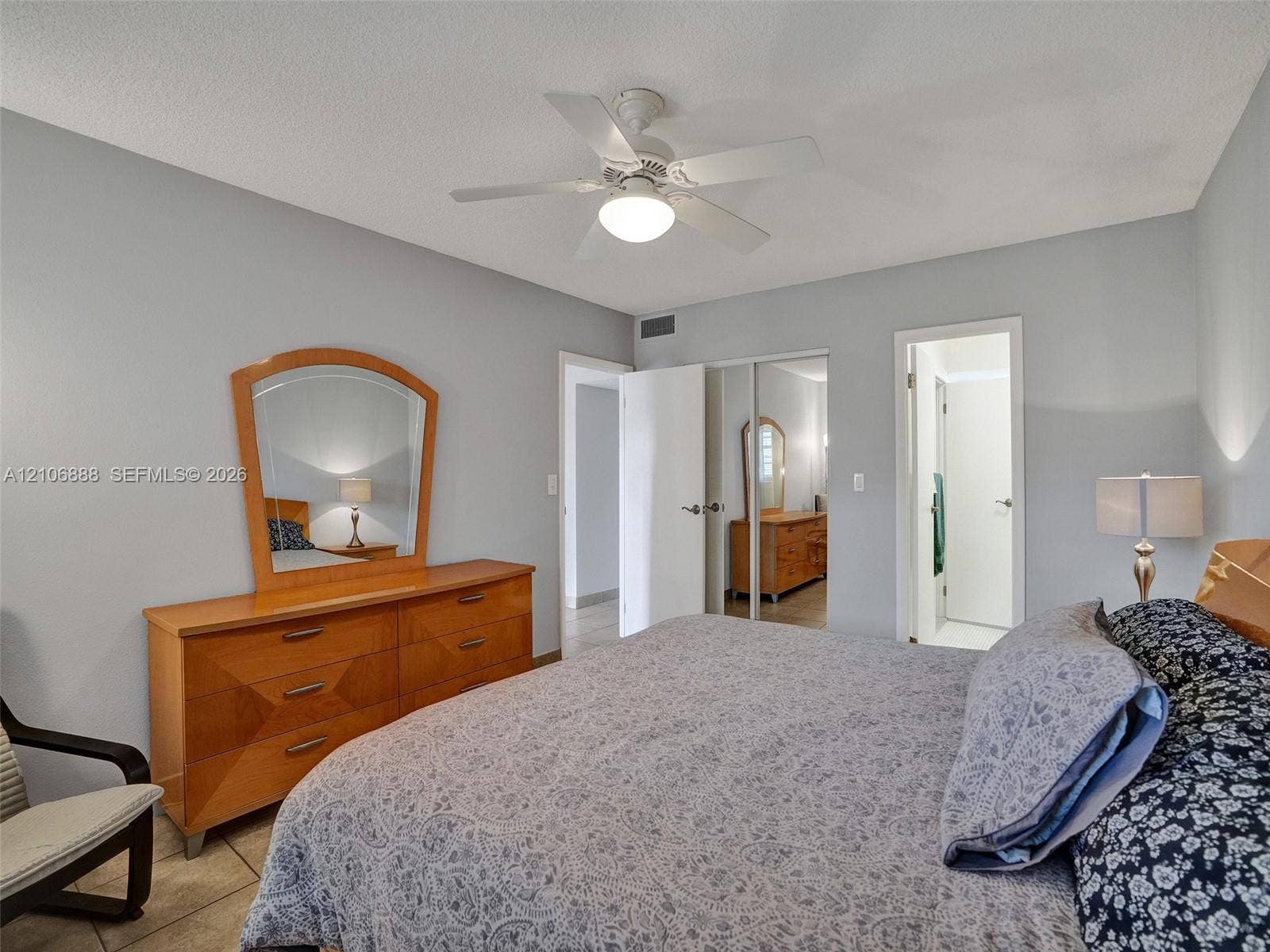 3506 NW 49th Avenue, #508, Lauderdale Lakes, FL 33319 Spacious room featuring neutral paint tones, ceramic tile flooring, a white ceiling fan with integrated lighting, and a dual-panel sliding closet with mirrored doors