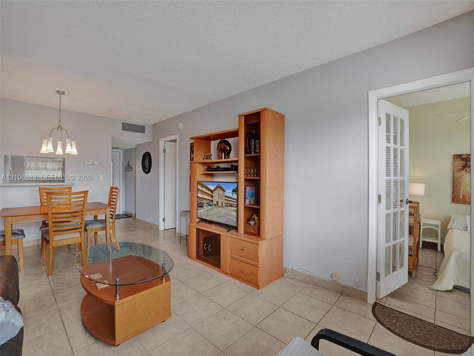 3506 NW 49th Avenue, #508, Lauderdale Lakes, FL 33319 Neutral tile flooring, multi-pane French door, and overhead chandelier lighting