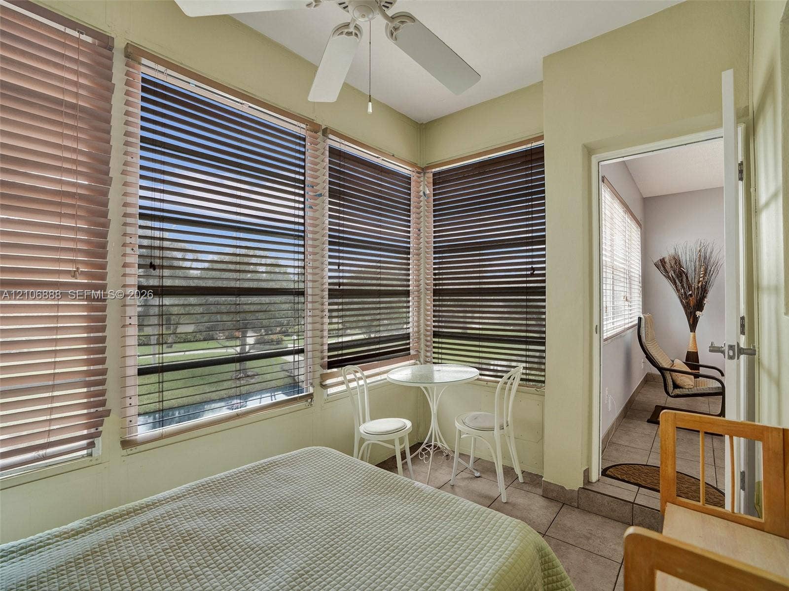 3506 NW 49th Avenue, #508, Lauderdale Lakes, FL 33319 Sunroom featuring ceramic tile flooring, a multi-blade ceiling fan, and wrap-around windows with installed horizontal blinds