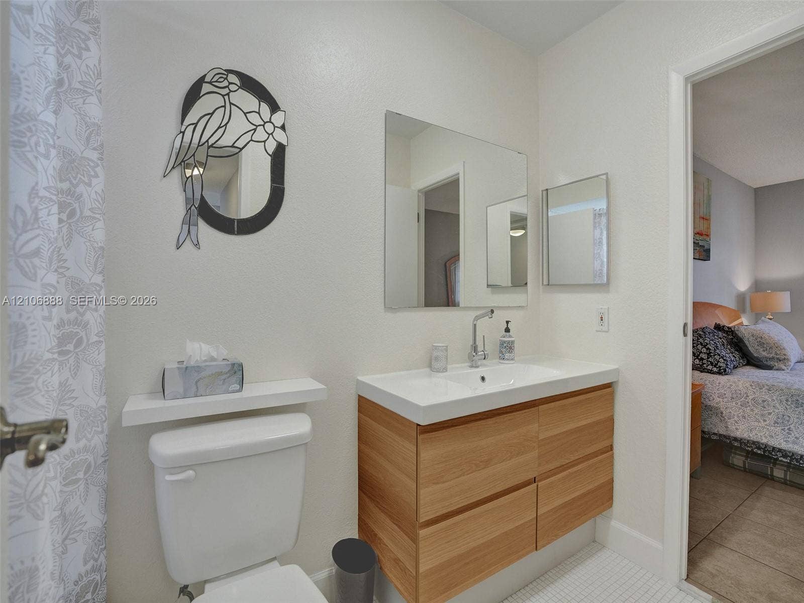 3506 NW 49th Avenue, #508, Lauderdale Lakes, FL 33319 Floating vanity with wood-finish cabinetry, rectangular integrated sink, wall-mounted faucet, and a wall-mounted shelf above the toilet