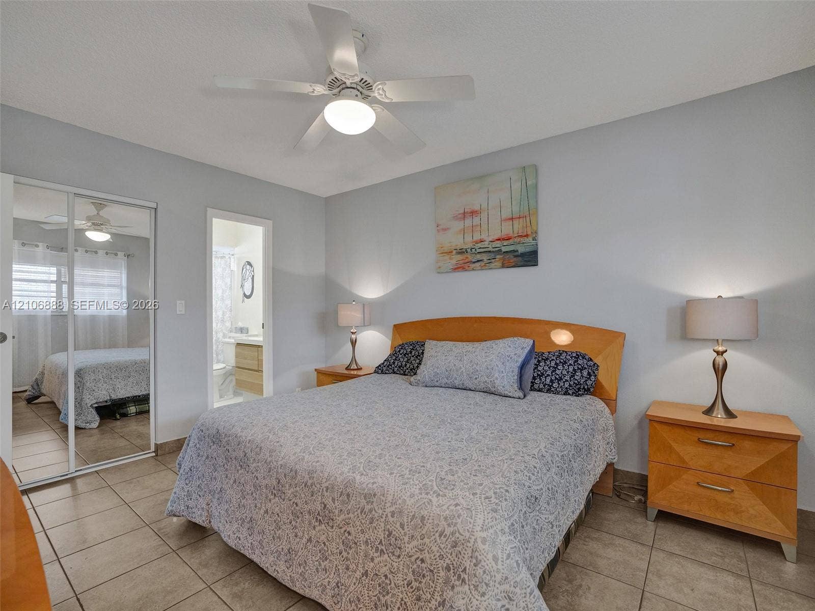 3506 NW 49th Avenue, #508, Lauderdale Lakes, FL 33319 Room featuring neutral-toned walls, tile flooring, a ceiling fan with integrated lighting, and a dual-panel mirrored sliding closet door