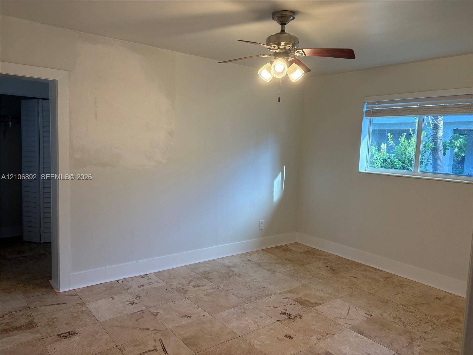 1322 N 31st Road, Hollywood, Hollywood, FL 33021 Room featuring large-format tile flooring, a multi-light ceiling fan with dark wood-finish blades, and a horizontal sliding window