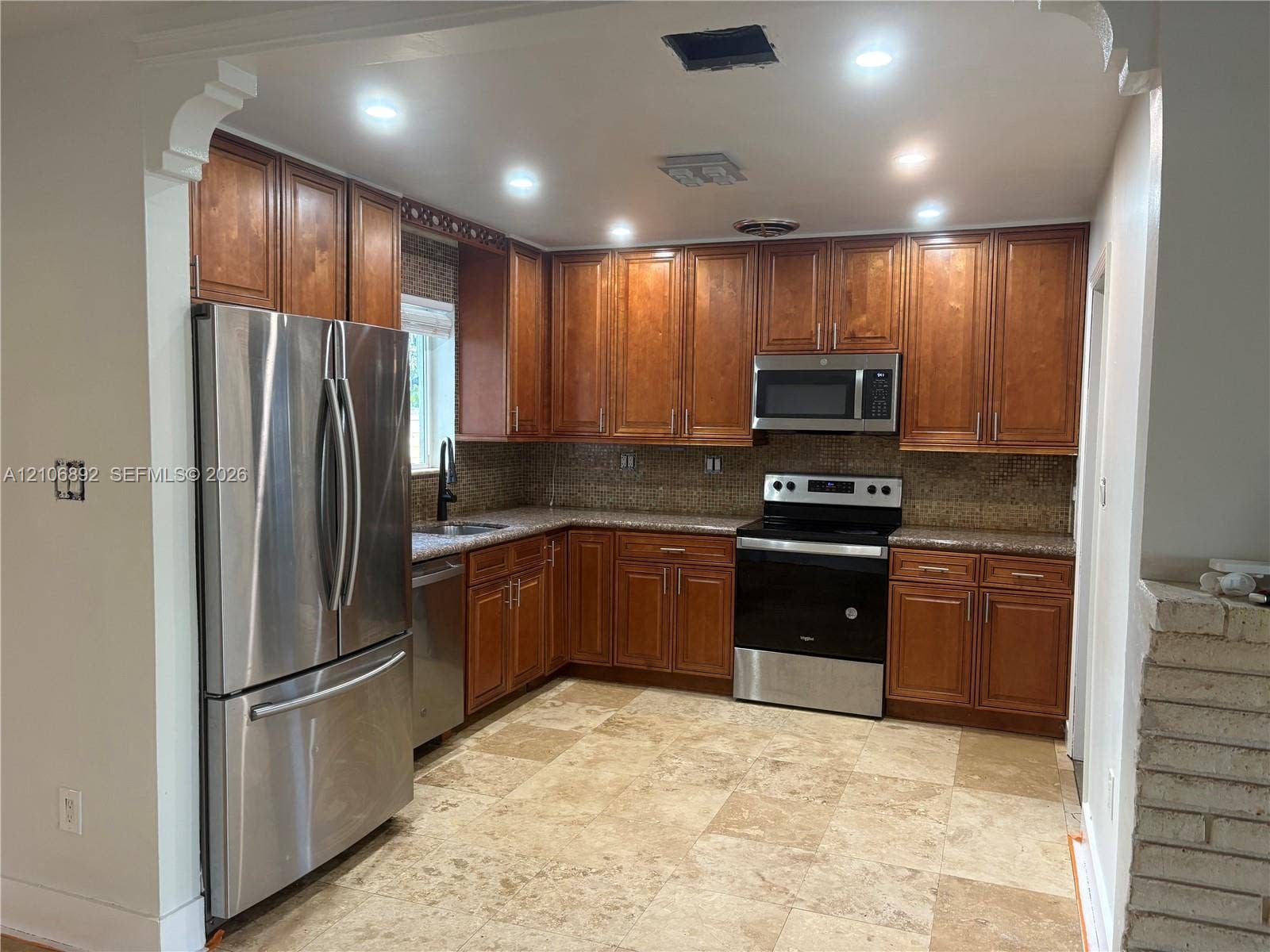 1322 N 31st Road, Hollywood, Hollywood, FL 33021 Kitchen featuring wood cabinetry, stainless steel appliances, stone-finish countertops, recessed lighting, and large-format tile flooring