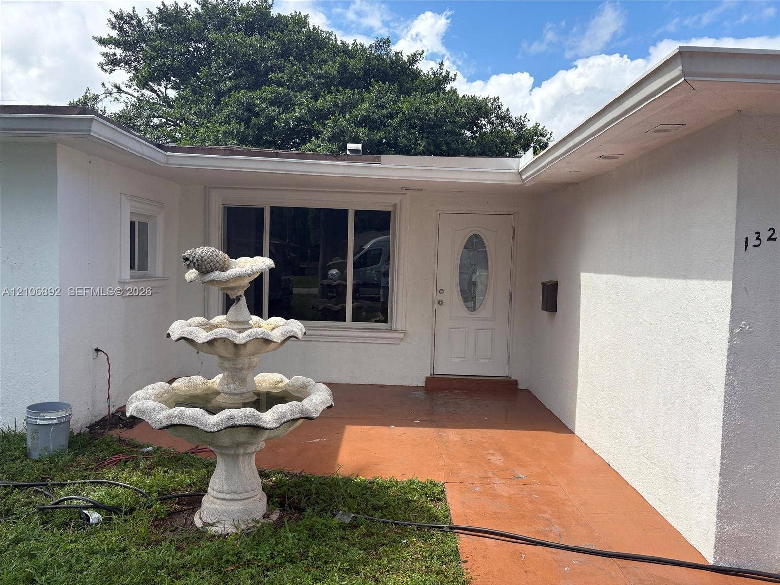 1322 N 31st Road, Hollywood, Hollywood, FL 33021 Stucco exterior featuring an entry patio, tiered stone fountain, and white front door with an oval glass insert