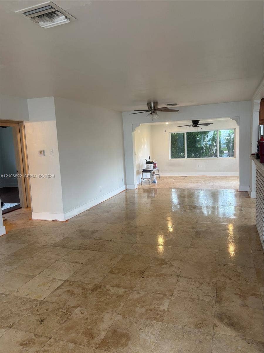 1322 N 31st Road, Hollywood, Hollywood, FL 33021 Large-format neutral stone flooring, dual ceiling fans, expansive windows, and arched architectural detailing