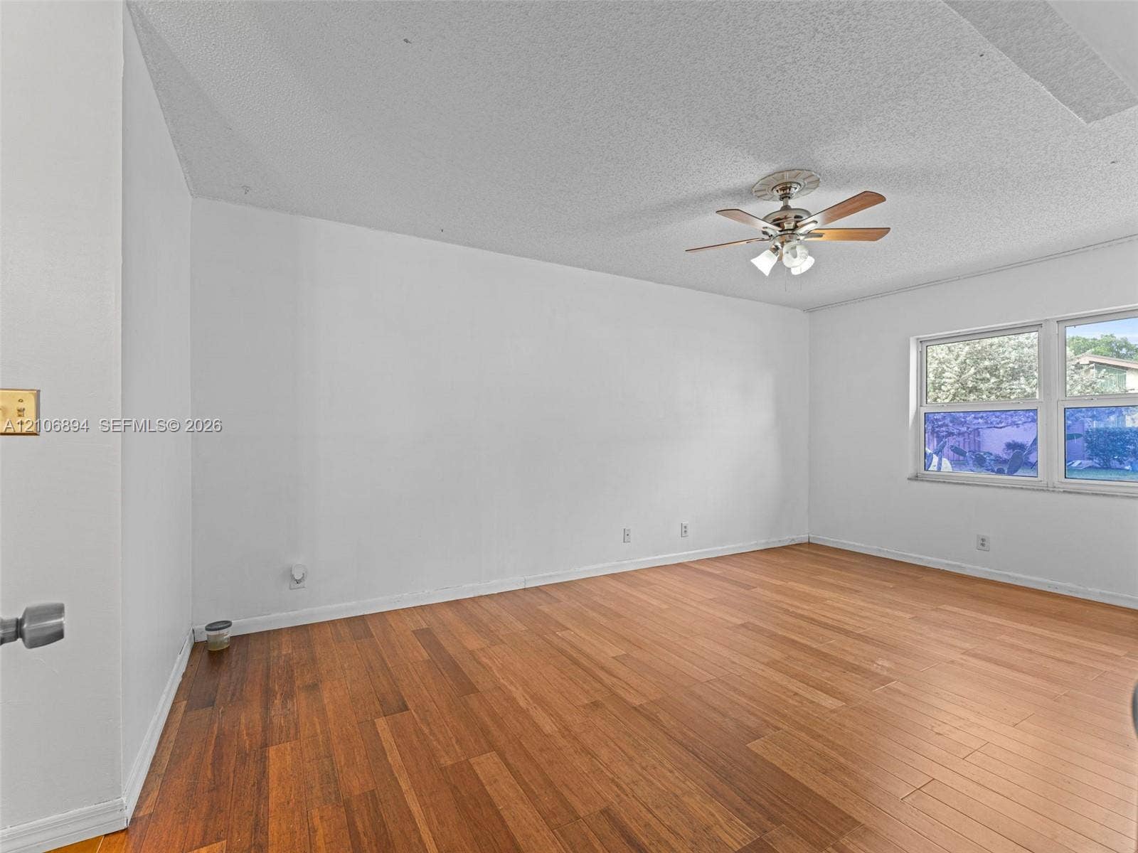 Wood-finish flooring, neutral walls, ceiling fan with light fixture, and horizontal sliding windows