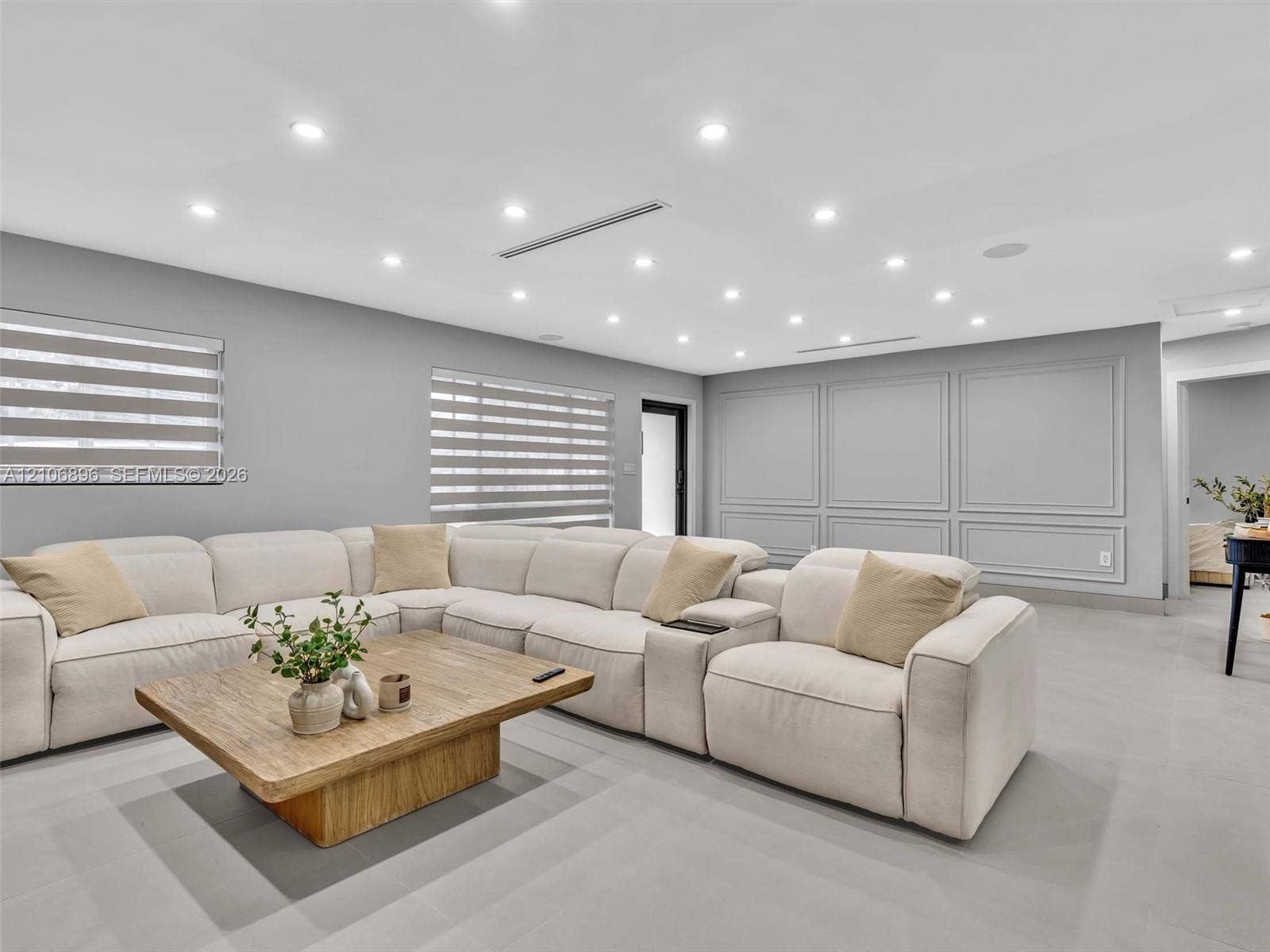 Interior space featuring recessed lighting, large-format tile flooring, wall molding detail, and dual-layered window shades