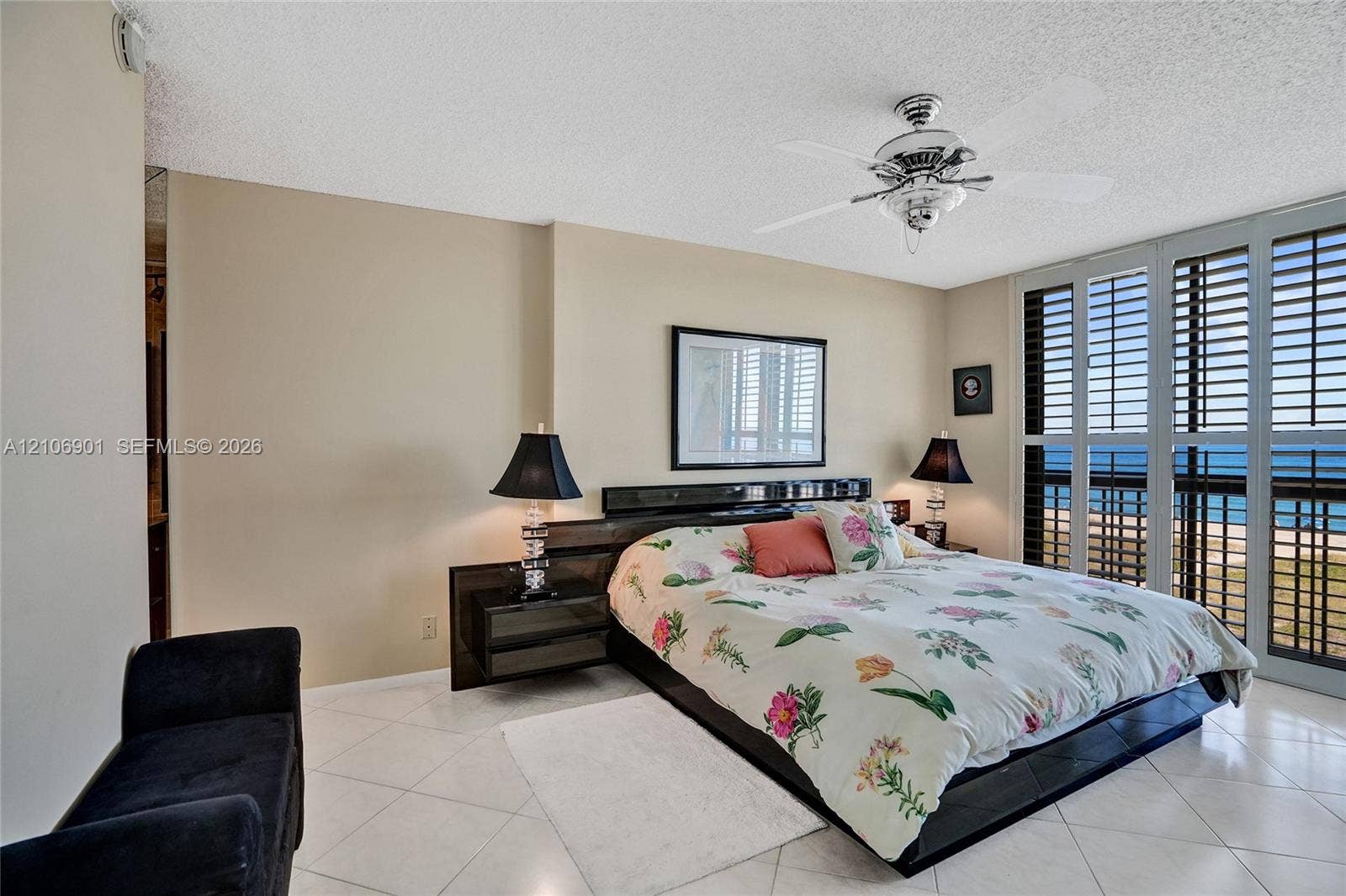 510 N Ocean Boulevard, #308, Pompano Beach, FL 33062 Floor-to-ceiling plantation shutters, neutral tile flooring, and a multi-blade ceiling fan with integrated lighting