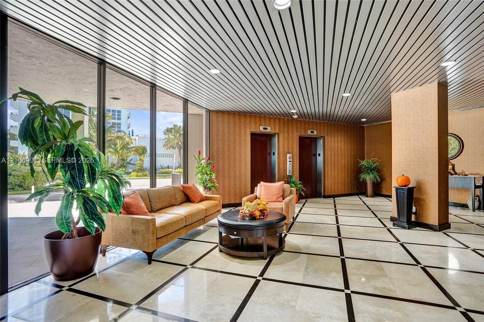 510 N Ocean Boulevard, #308, Pompano Beach, FL 33062 Floor-to-ceiling glass wall, linear metal-panel ceiling, tiled flooring with geometric inlay, and dual elevator access